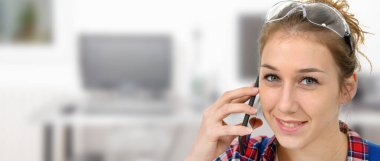Güzel genç bayan marangoz akıllı telefonla konuşuyor.