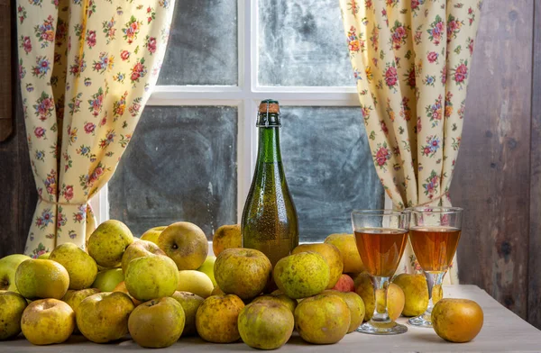 Bottle and glasses of cider with apples, near the window, in rus — Stock Photo, Image