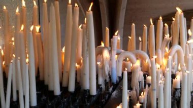 Lourdes kilisesinde mumlar, dini semboller.