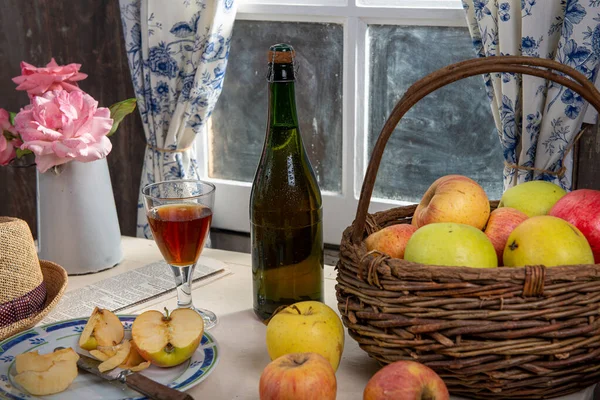 Bottle and glass of cider with apples. In rustic house — Stock Photo, Image