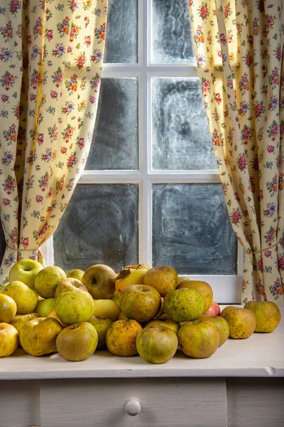 Pila de manzanas orgánicas en una mesa cerca de la ventana — Foto de Stock