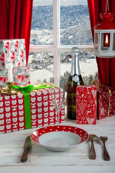 Christmas gifts, champagne and plate near rustic window — Stock Photo, Image