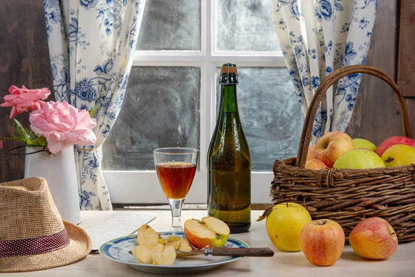 Bottle and glass of cider with apples. In rustic house — Stock Photo, Image