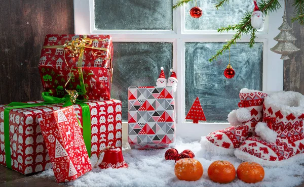 Kerstconcept met pantoffels, sinaasappels en geschenken — Stockfoto