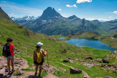 Fransız Pirenesi dağlarında Pic du Midi Ossau yolunda iki yürüyüşçü kadın.