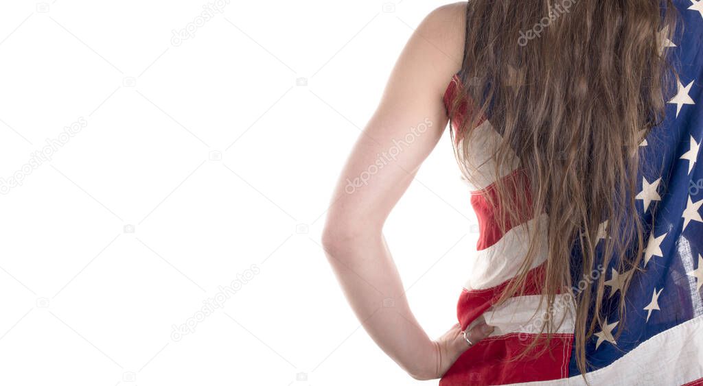 beautiful young woman wrapped in American flag on white background