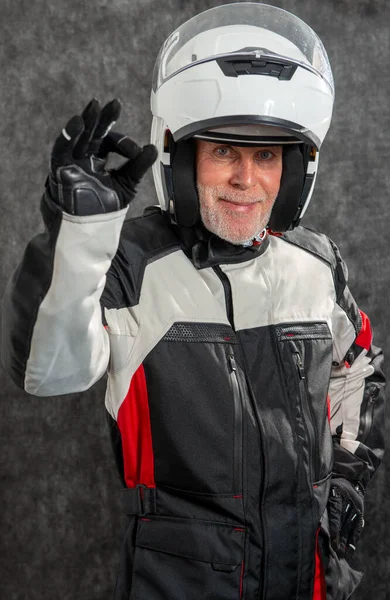 portrait of a senior biker with white helmet make OK