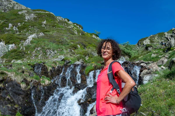 野生の水しぶき滝の近くの女性ハイカー — ストック写真