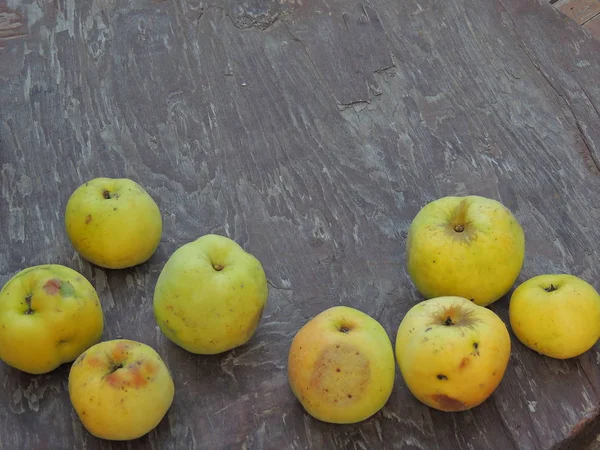 apples in the grass against a wooden frame.