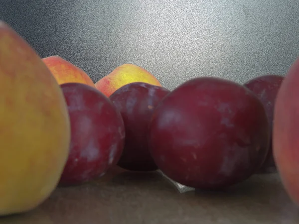 plums and peaches on the background of old burlap.