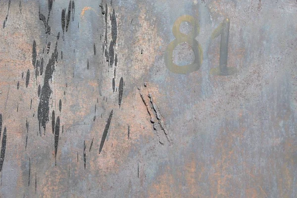 Old and rusty sheet metal smeared with tar,background. Painted number 81.