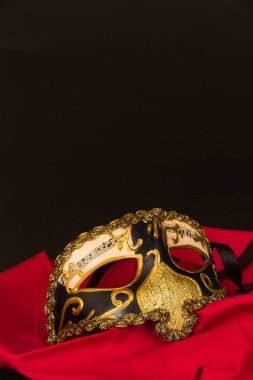 Venedik maske siyah arka plan ve boşaltmak kırmızı malzeme üzerinde.