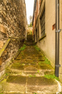 Taş basamaklar ile eski binalar arasında yol.