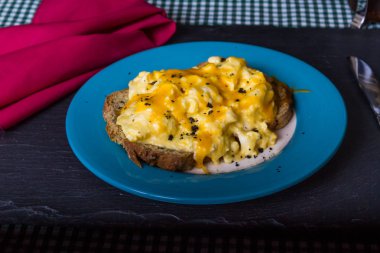 Rendelenmiş peynir, kömür tuzu ve r ile tepesinde omlet