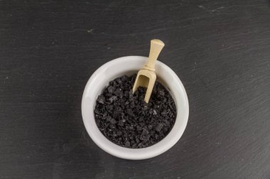 Siyah kömür deniz tuzu gevreği ve kepçe.