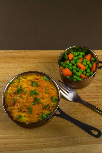 Shepherds or cottage pie in serving dish with parsley, portrait. — Stock Photo, Image