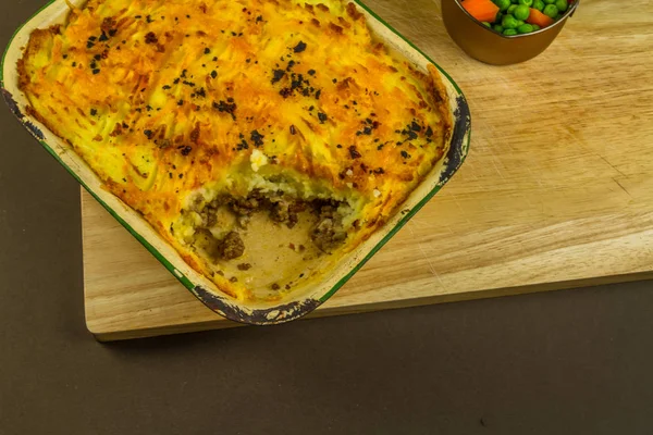 Pastori o torta cottage nel piatto di servizio, una porzione presa . — Foto Stock