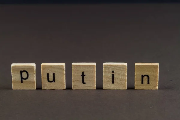 Blocos de letras de madeira ortografia Putin, fundo escuro . — Fotografia de Stock