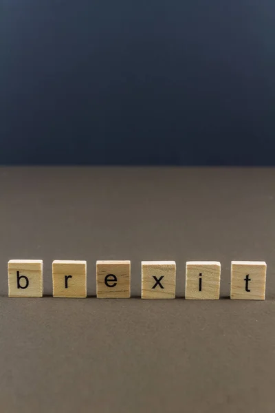 Дерев'яний лист блокує правопис Brexit, темний фон портрет. — стокове фото