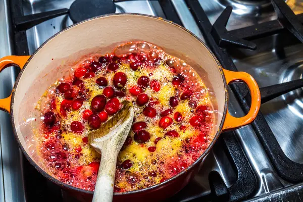 Cranberry dan jus jeruk yang dimasak untuk membuat saus dengan woo — Stok Foto