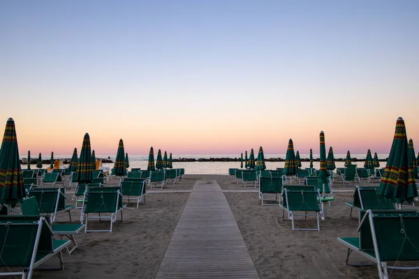 Ομπρέλες Παραλίας Και Ξαπλώστρες Ηλιοβασίλεμα Πανέμορφος Ροζ Ουρανός Ιταλική Αδριατική — Φωτογραφία Αρχείου