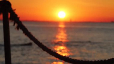 Çocuk gün batımında sahilde oynuyor.