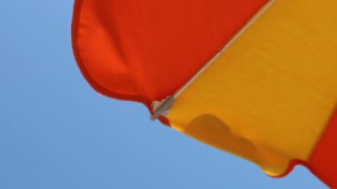 Güneş şemsiyesi rüzgarda savruluyor.