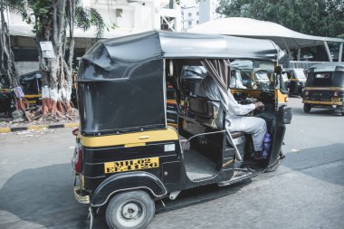 Tuk Tuk Mumbai yollarında at sürüyor.
