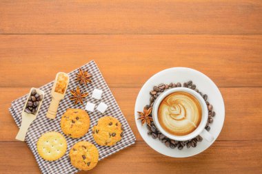 Bir fincan kahve çerezler ve kraker ile ahşap üzerine yukarıdan mola süresi için masa veya kopya alanı ile zaman sakin ol.