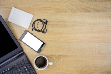 Ofis büro dizüstü bilgisayar, akıllı telefon, dizüstü bilgisayar, kulaklık ve kopya alanı ile ahşap masa kahve. Üstten görünüm, iş yeri kavramı.