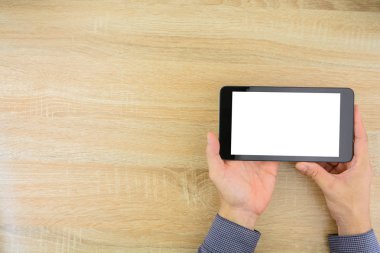 Online çalışma evde ahşap masa üzerinde office beyaz bir ekran ile dijital tablet holding iş adamı. Metin için yer kopyalayın.