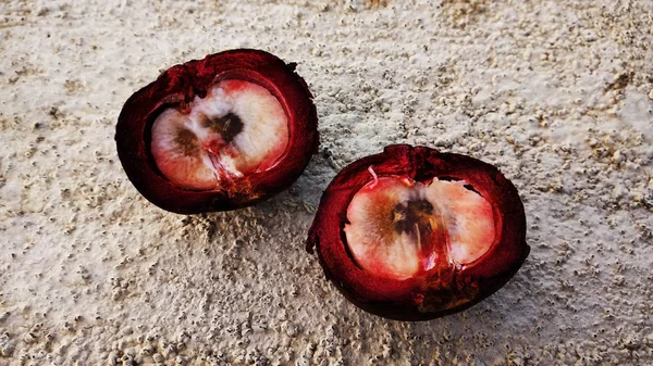 Mangosteen ve enine kesitleri, meyvelerin kraliçesinin kalın mor derisini ve beyaz etini gösteriyor, lezzetli mangosteen meyvesi bir kasede dizilmiş, Mangosteen eti, yakın çekim. Mangosteen