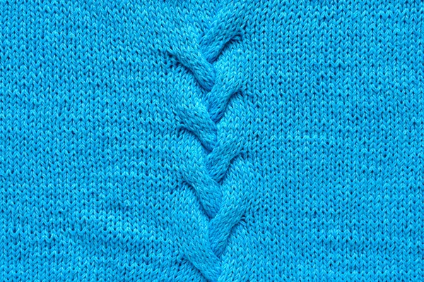 Трикотажная ткань из голубой пряжи. Косички ручной работы. Фоновая текстура . — стоковое фото