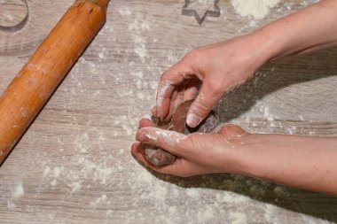 Eller hamuru ahşap bir masada yoğurur. Yakın plan. Para kazanma teknolojisi.
