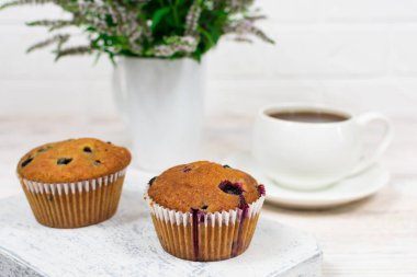 Siyah üzümlü kekler ve beyaz tabakta nane yaprakları. Seçici odak.
