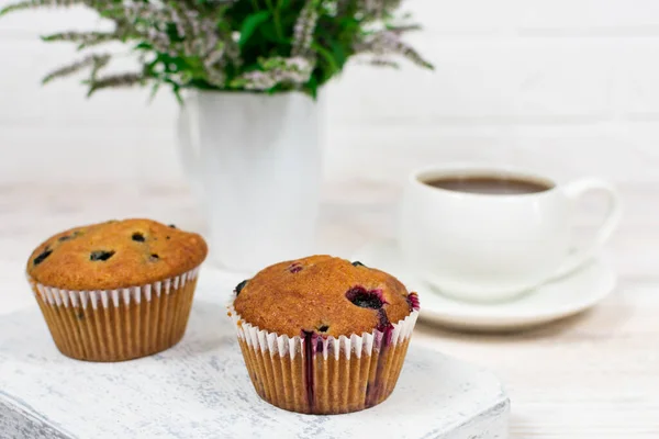 Cupcakes med svarta vinbär och mynta blad på en vit platta. Selektiv inriktning. — Stockfoto