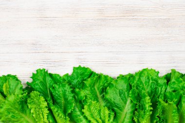 Beyaz ahşap bir masada taze yeşil salata. Yazı için uygun bir yer. Fto kapatılıyor.
