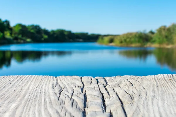 Tablero de madera envejecida sobre el telón de fondo de un paisaje con un lago claro, bosque y cañas. Severodonetsk. Lago Kleshnya. — Foto de Stock