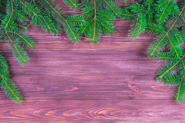 Ramos verdes de uma árvore de Natal em um contexto de madeira escuro. Lugar para uma inscrição. A base para o cartão postal. Espaço de cópia. — Fotografia de Stock