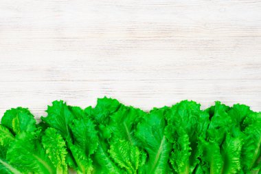 Beyaz ahşap bir masada taze yeşil salata. Yazı için uygun bir yer. Fto kapatılıyor.