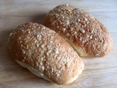 Üst katta kırıntıları ile iki lezzetli yumuşak çörekler ahşap bir masa üzerinde yan yana yalan