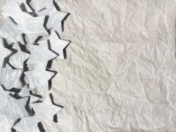 crumpled white paper background with silver stars