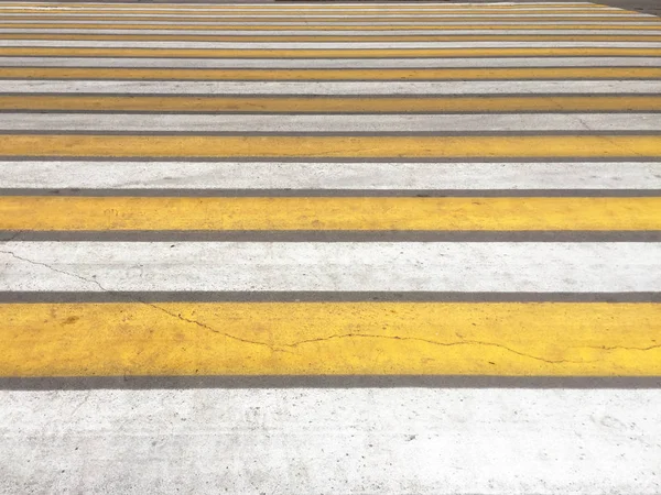 Zebra traffic pedestrian walkway in the city. Yellow and white stripes.