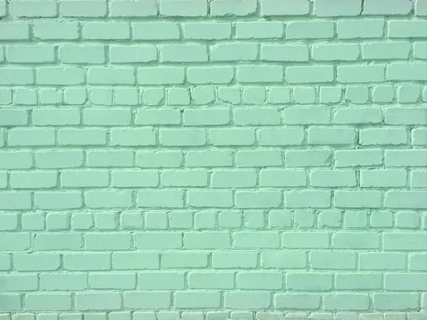 The brick wall is painted green. Background and texture. Can be used in the interior.