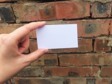 Eski tuğla duvar arka plan üzerinde kadın elinde Boş kartvizit, metin için yer