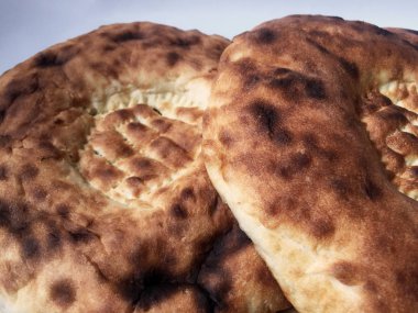 Lezzetli yumuşak ekmek. Yuvarlak kızarmış tortilla lar tahta bir masanın üzerine uzanır. Yakın çekim, üst görünüm.