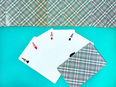 Farklı takım elbiseli eski iskambil kartları nın dört asve mavi bir arka plan üzerinde onlarla bir ters kart kazanan bir poker eli. Üst sıra ters kapalı oyun kartları. Üst görünüm, yakın çekim.