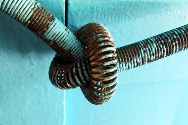 Eski paslı kırık yay eski ahşap kapı mavi boyalı. Bahar düğümlendi. Close.