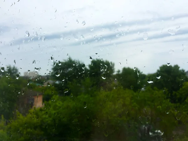 Gotas Lluvia Sobre Cristal Nubes Árboles Verdes Fuera Ventana — Foto de Stock