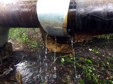 Isıtma ve su temini için kırık borular. Su büyük bir borudan toprağa akar..